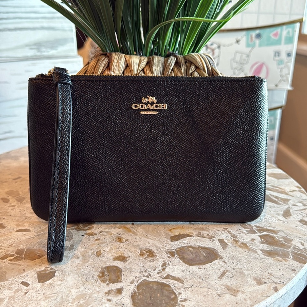 Coach black leather wristlet with six credit card holders inside.